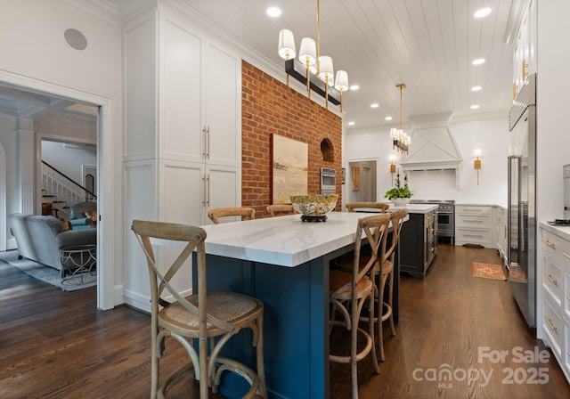 2324 Kingsmill Ter, Charlotte, NC 28270 - kitchen with a spacious island, custom exhaust hood, premium appliances, a kitchen bar, and white cabinetry