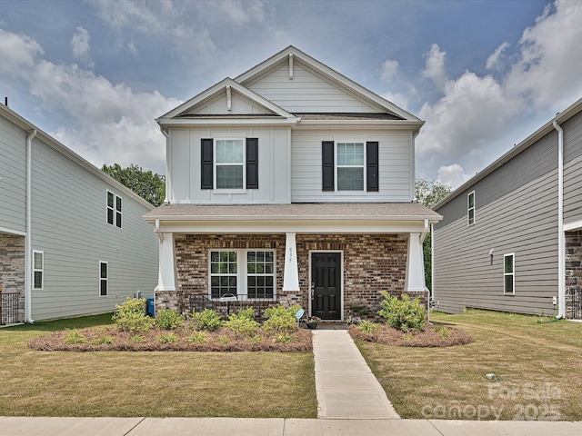 835 Windage Way, Pineville, NC 28134 - craftsman-style house with covered porch, brick siding, a front yard, and board and batten siding