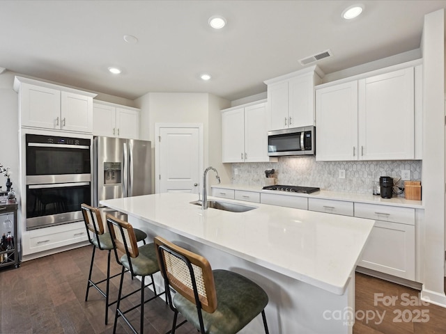 835 Windage Way, Pineville, NC 28134 - kitchen featuring stainless steel appliances, a breakfast bar, backsplash, white cabinets, and recessed lighting