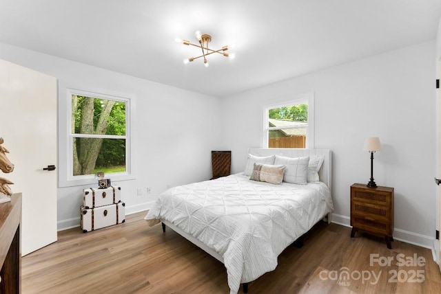1426 Larkfield Ln, Charlotte, NC 28210 - bedroom with multiple windows, wood finished floors, and a chandelier