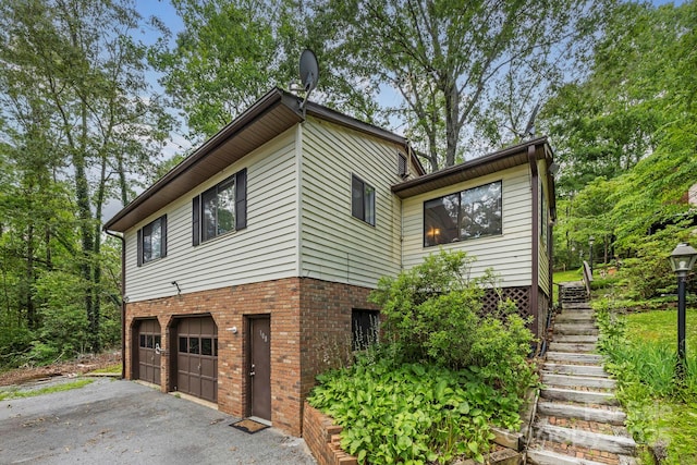 108 Deer Run Rd, Mills River, NC 28759 - view of home's exterior with stairs, an attached garage, brick siding, and driveway