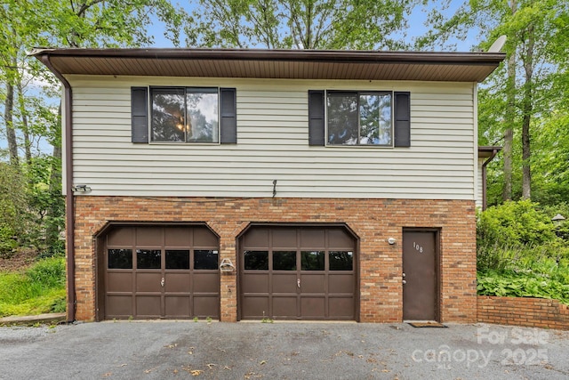 108 Deer Run Rd, Mills River, NC 28759 - view of home's exterior featuring brick siding, an attached garage, and asphalt driveway