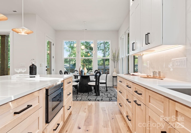 1622 Burtonwood Cir, Charlotte, NC 28212 - kitchen with stainless steel microwave, light wood-style floors, light brown cabinets, and pendant lighting