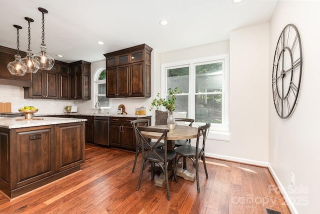 205 Rosedale Ln, Matthews, NC 28105 - kitchen with stainless steel dishwasher, dark brown cabinetry, decorative backsplash, dark wood finished floors, and glass insert cabinets