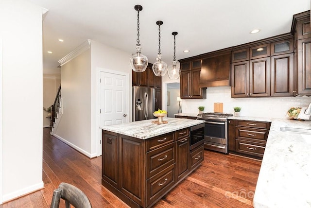 205 Rosedale Ln, Matthews, NC 28105 - kitchen with stainless steel appliances, custom range hood, dark brown cabinets, glass insert cabinets, and decorative light fixtures