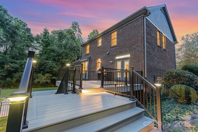 205 Rosedale Ln, Matthews, NC 28105 - back of property at dusk with brick siding and a wooden deck