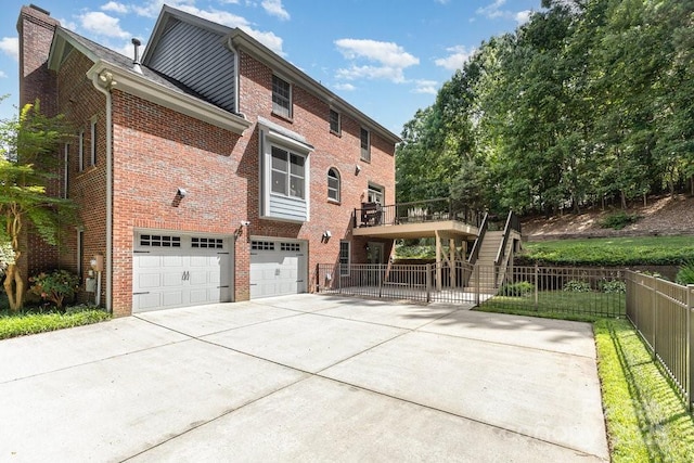 205 Rosedale Ln, Matthews, NC 28105 - rear view of house featuring concrete driveway, an attached garage, brick siding, and a deck