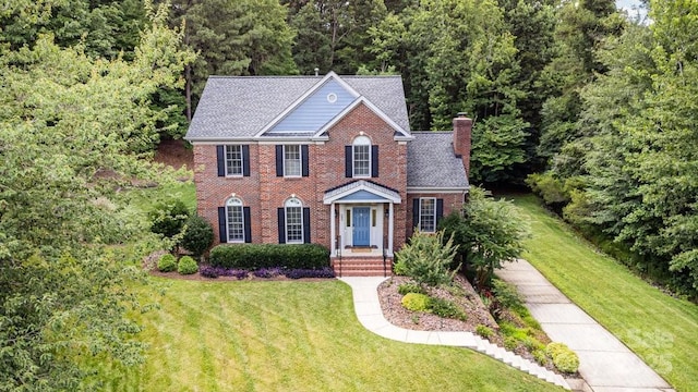 205 Rosedale Ln, Matthews, NC 28105 - view of front of property with brick siding, a chimney, a front yard, and a view of trees