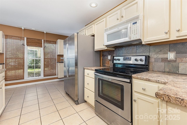 2001 Enderbury Dr, Indian Trail, NC 28079 - kitchen with stainless steel appliances, light countertops, light tile patterned flooring, and decorative backsplash