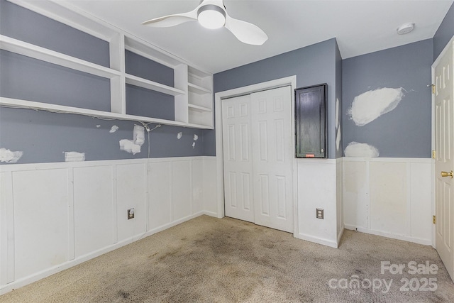 2001 Enderbury Dr, Indian Trail, NC 28079 - unfurnished bedroom featuring a wainscoted wall, carpet, a closet, a ceiling fan, and a decorative wall