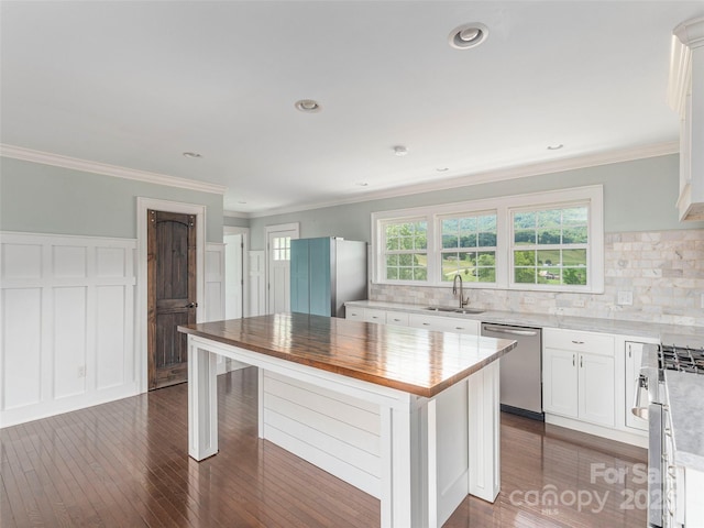 3355 Thickety Rd, Clyde, NC 28721 - kitchen with stainless steel appliances, white cabinetry, dark wood-style floors, decorative backsplash, and ornamental molding