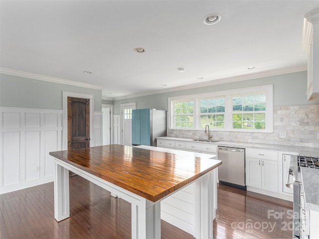 3355 Thickety Rd, Clyde, NC 28721 - kitchen featuring stainless steel appliances, white cabinetry, dark wood finished floors, crown molding, and tasteful backsplash