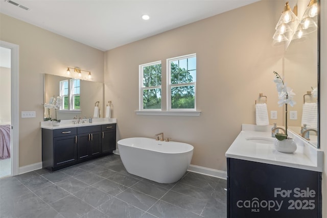 8680 Sherrills Ford Rd, Sherrills Ford, NC 28673 - full bathroom featuring two vanities, a freestanding tub, recessed lighting, and marble look tiles