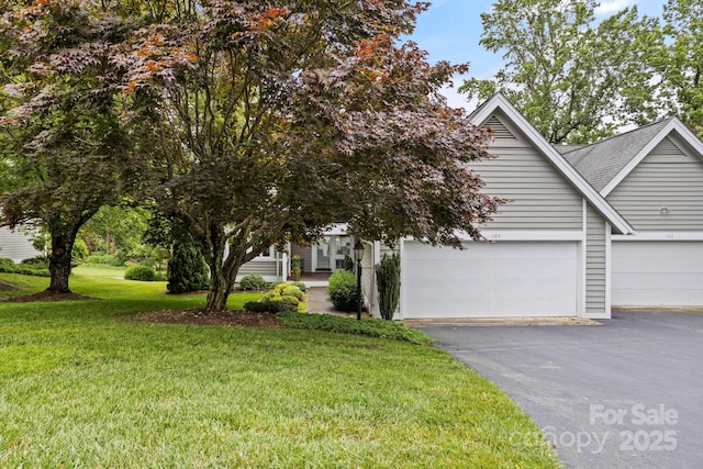 104 Overlook Dr, Flat Rock, NC 28731 - view of property hidden behind natural elements featuring asphalt driveway, a front lawn, and a shingled roof