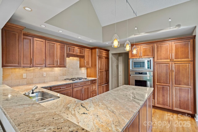 104 Overlook Dr, Flat Rock, NC 28731 - kitchen featuring stainless steel appliances, recessed lighting, a peninsula, brown cabinetry, and vaulted ceiling