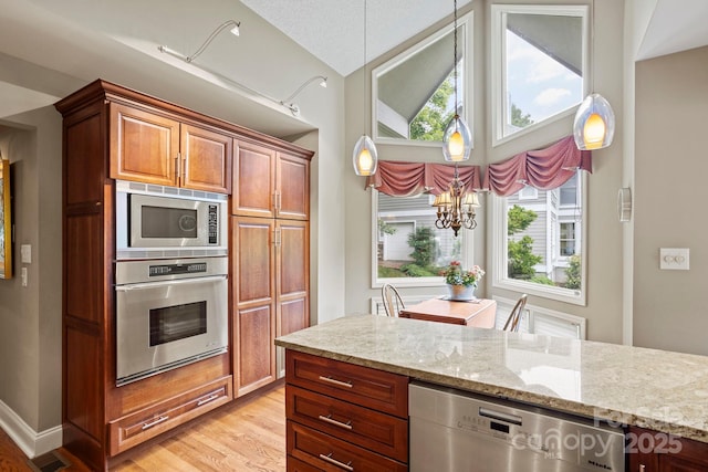 104 Overlook Dr, Flat Rock, NC 28731 - kitchen featuring appliances with stainless steel finishes, light wood-style flooring, light stone counters, plenty of natural light, and lofted ceiling