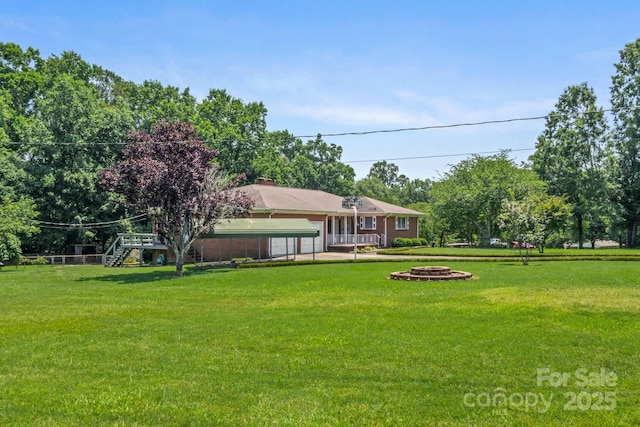128 Howie St, Mount Holly, NC 28120 - view of green lawn featuring an outdoor fire pit and view of scattered trees