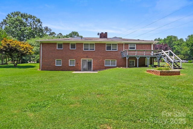 128 Howie St, Mount Holly, NC 28120 - rear view of house with a chimney, a yard, stairway, and brick siding