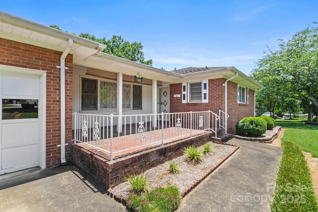 128 Howie St, Mount Holly, NC 28120 - view of exterior entry with covered porch and brick siding