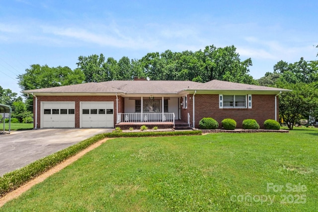 128 Howie St, Mount Holly, NC 28120 - ranch-style house featuring a porch, brick siding, a garage, and a front lawn
