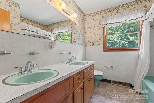 128 Howie St, Mount Holly, NC 28120 - full bathroom featuring wallpapered walls, double vanity, shower / bath combination with curtain, and wainscoting