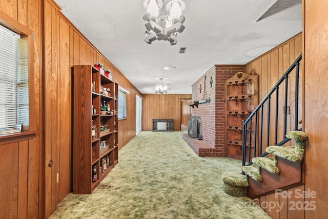 128 Howie St, Mount Holly, NC 28120 - hall featuring a chandelier, wooden walls, carpet floors, stairway, and a textured ceiling