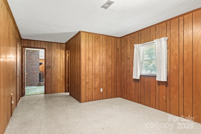 128 Howie St, Mount Holly, NC 28120 - carpeted spare room with a textured ceiling and wood walls