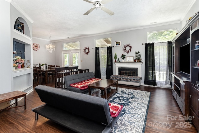 9520 Marshbrooke Rd, Matthews, NC 28105 - living area with a chandelier, ornamental molding, a ceiling fan, dark wood finished floors, and a glass covered fireplace