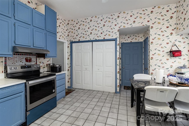 9520 Marshbrooke Rd, Matthews, NC 28105 - kitchen featuring stainless steel electric range, under cabinet range hood, blue cabinets, wallpapered walls, and light countertops