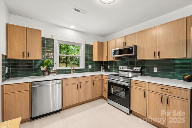5320 Kildare Dr, Charlotte, NC 28215 - kitchen with appliances with stainless steel finishes, light countertops, backsplash, light flooring, and recessed lighting