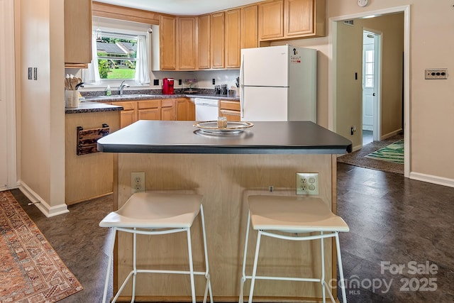 5922 Sullins Rd, Charlotte, NC 28214 - kitchen with white appliances, dark countertops, a kitchen breakfast bar, and a kitchen island