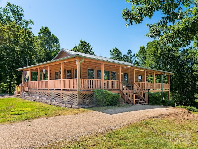 129 Melrose Lake Rd, Saluda, NC 28773 - view of front of house featuring covered porch, a metal roof, a front lawn, and driveway