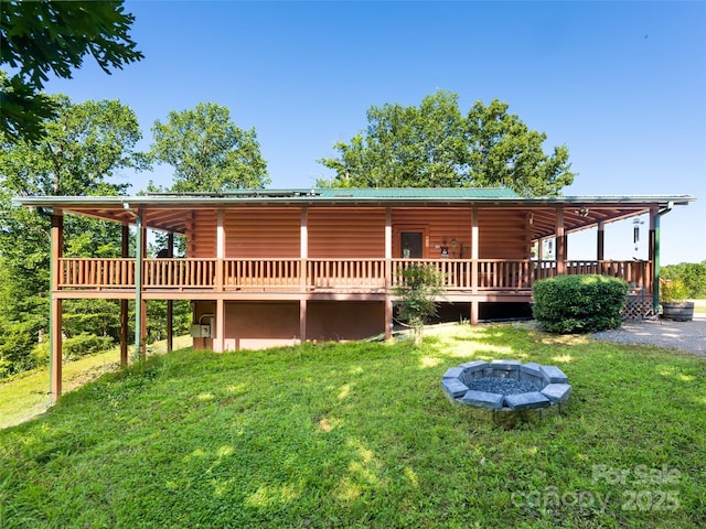 129 Melrose Lake Rd, Saluda, NC 28773 - back of property featuring a fire pit, a lawn, a wooden deck, and log siding