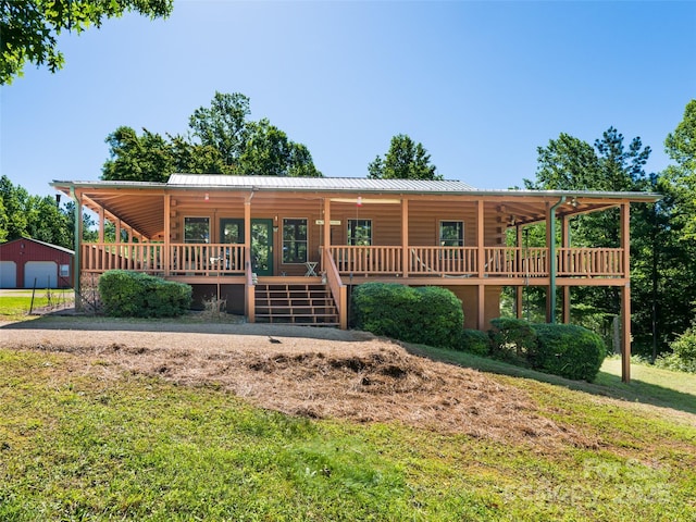 129 Melrose Lake Rd, Saluda, NC 28773 - view of front of property featuring a front yard, a porch, a metal roof, log exterior, and driveway
