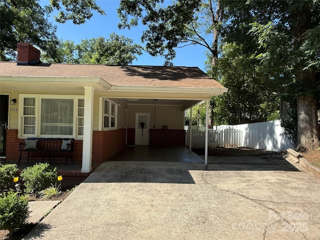 708 E St Unit 8, 9, Albemarle, NC 28001 - view of front of property featuring concrete driveway, brick siding, a chimney, and an attached carport