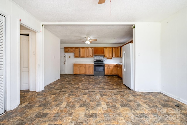 1043 Sid Davis Rd, Chester, SC 29706 - kitchen featuring electric range, a ceiling fan, freestanding refrigerator, dark stone finish flooring, and a textured ceiling