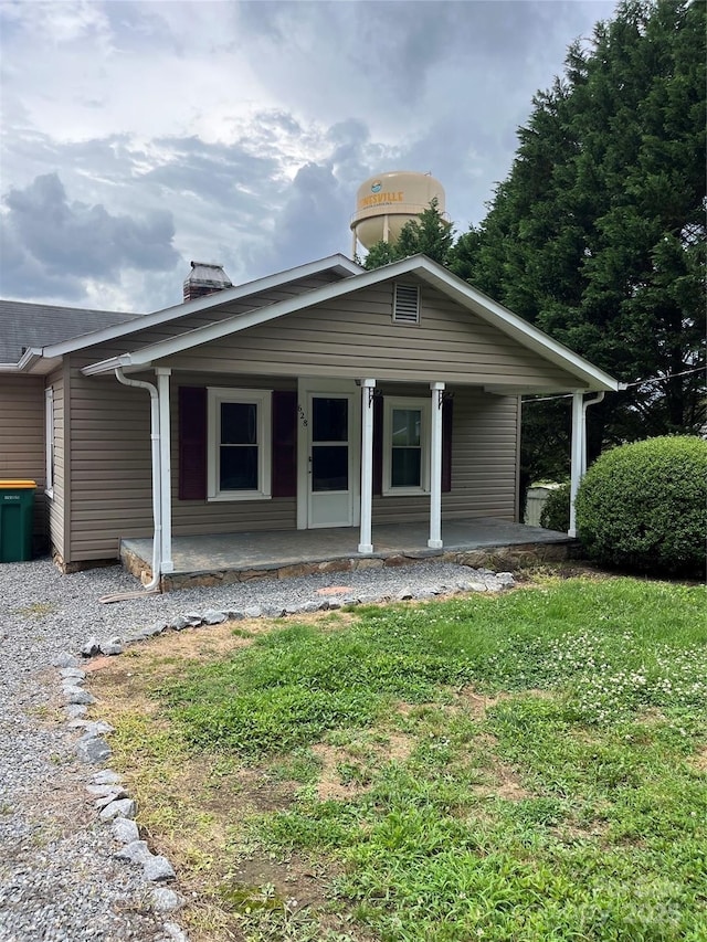 628 Main St S, Jonesville, NC 29353 - view of front facade featuring a chimney, a porch, and a front lawn