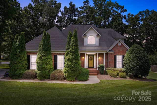 803 Woodmoore Ln, Kannapolis, NC 28081 - traditional home featuring brick siding, a front lawn, a shingled roof, and a garage