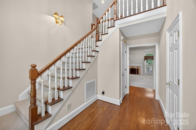 803 Woodmoore Ln, Kannapolis, NC 28081 - stairs featuring wood finished floors, a fireplace, and a towering ceiling