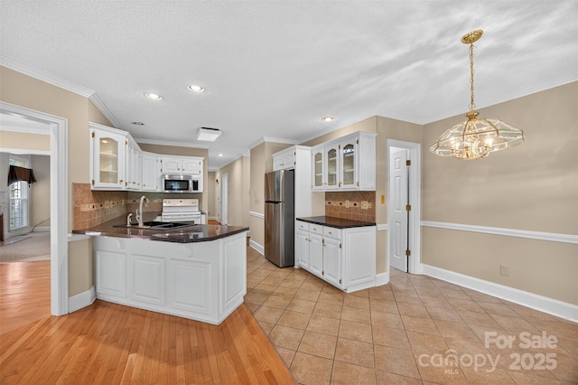803 Woodmoore Ln, Kannapolis, NC 28081 - kitchen with appliances with stainless steel finishes, a peninsula, glass insert cabinets, decorative backsplash, and recessed lighting