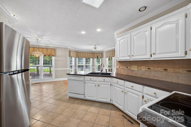 803 Woodmoore Ln, Kannapolis, NC 28081 - kitchen featuring white appliances, dark countertops, a peninsula, healthy amount of natural light, and recessed lighting