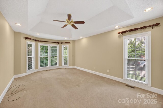 803 Woodmoore Ln, Kannapolis, NC 28081 - spare room featuring a tray ceiling, light colored carpet, ceiling fan, and recessed lighting