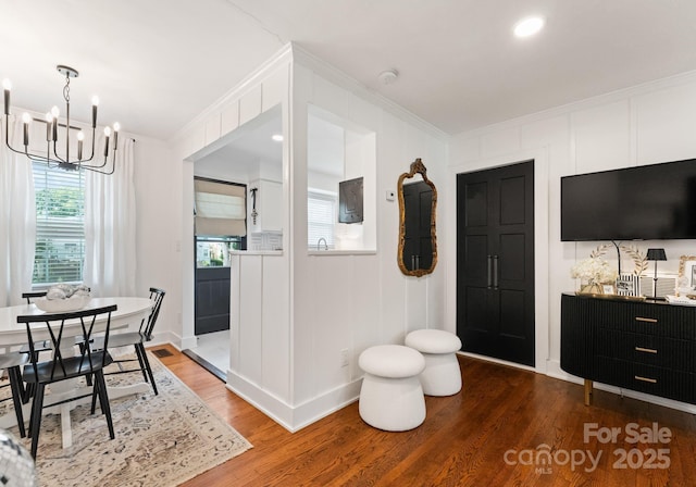 504 Wakefield Dr Unit A, Charlotte, NC 28209 - dining room featuring wood finished floors, ornamental molding, a chandelier, and a decorative wall