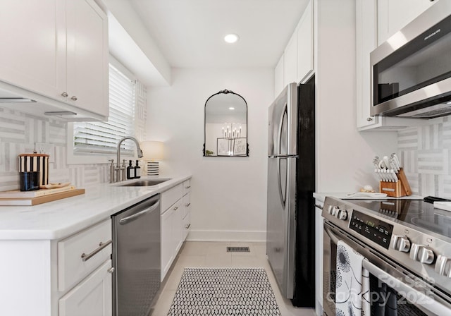 504 Wakefield Dr Unit A, Charlotte, NC 28209 - kitchen with stainless steel appliances, backsplash, white cabinets, light tile patterned floors, and light countertops