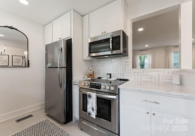 504 Wakefield Dr Unit A, Charlotte, NC 28209 - kitchen featuring stainless steel appliances, backsplash, white cabinetry, recessed lighting, and light stone counters