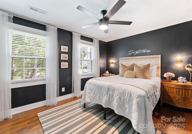 504 Wakefield Dr Unit A, Charlotte, NC 28209 - bedroom with wood finished floors, an accent wall, and a ceiling fan