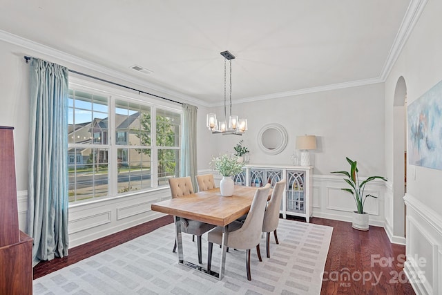 1335 Bryson Gap Dr, Fort Mill, SC 29715 - dining space featuring arched walkways, wood finished floors, ornamental molding, a chandelier, and a decorative wall