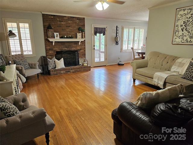 217 Rock Creek Dr, Lincolnton, NC 28092 - living area featuring hardwood / wood-style flooring, ornamental molding, ceiling fan, and a brick fireplace