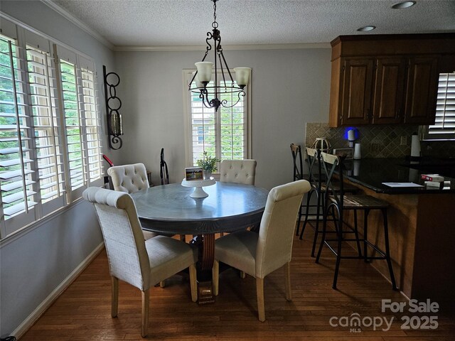 217 Rock Creek Dr, Lincolnton, NC 28092 - dining room featuring dark wood-style floors, ornamental molding, a textured ceiling, and a chandelier