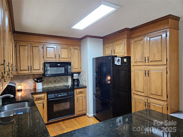 217 Rock Creek Dr, Lincolnton, NC 28092 - kitchen with black appliances, a textured ceiling, light wood-type flooring, dark stone counters, and tasteful backsplash